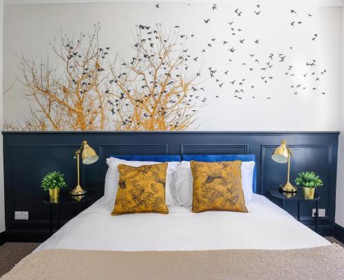 a bedroom with a bed with birds on the wall at 5 bed central home- beautiful modern in Witney