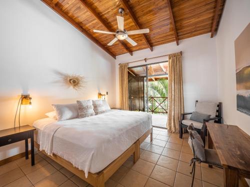 a bedroom with a bed and a ceiling fan at Beach Heaven in Playa Guiones