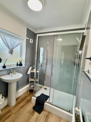 a bathroom with a shower and a sink at Comfortable 3BR house-parking close to city centre in Kidlington