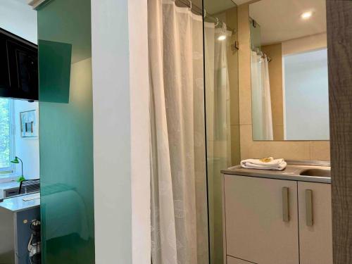 a bathroom with a shower curtain and a sink at Kubo Hotel & Business Center in San Miguel de Allende