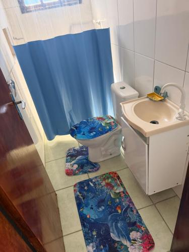a bathroom with a toilet and a sink at Pousada Mar e Sol in Peruíbe