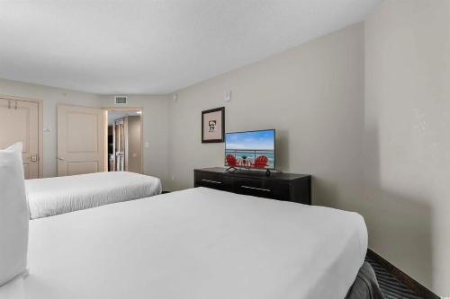 a hotel room with two beds and a flat screen tv at Experience the ultimate beachfront lifestyle at Oceans One 1 Bdr with three queen beds in Myrtle Beach