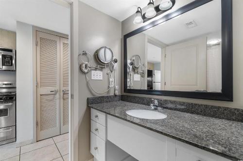 a bathroom with a sink and a large mirror at Experience the ultimate beachfront lifestyle at Oceans One 1 Bdr with three queen beds in Myrtle Beach