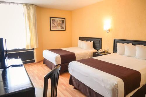 a hotel room with two beds and a television at Hotel Santa Irene Guadalajara in Guadalajara
