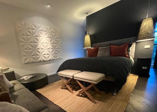 a bedroom with a bed and a chair and a couch at Oakwood Guesthouse in Berrima