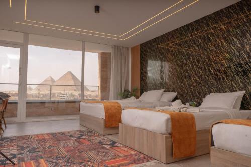 a bedroom with two beds and a view of the pyramids at pyramids view suite/vista piramidi in Cairo