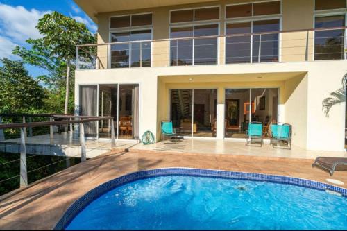 a house with a swimming pool in front of a house at Casa de Fox - Confort en medio de la jungla! in Manuel Antonio