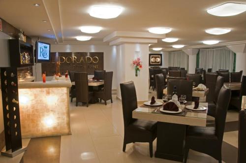 a restaurant with black chairs and tables and a bar at Hotel Real Rex in León