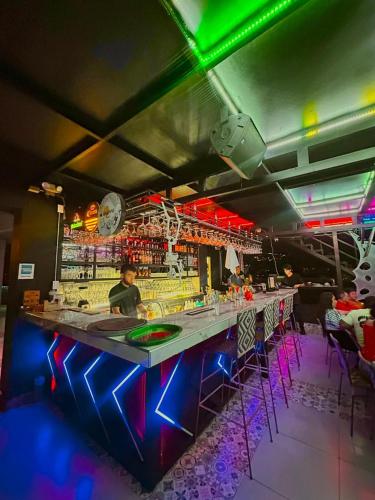 a bar with a long counter with neon lights at Santelmo Hotel Cali in Cali