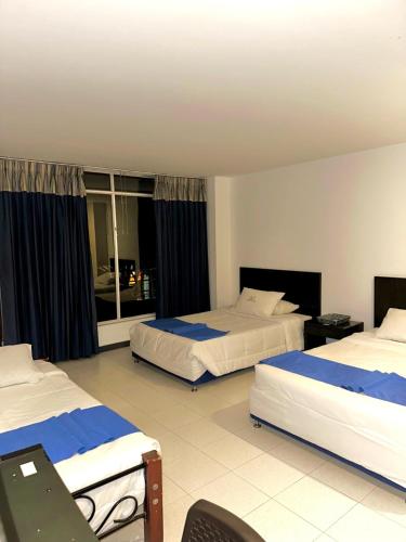 a hotel room with two beds and a window at Santelmo Hotel Cali in Cali