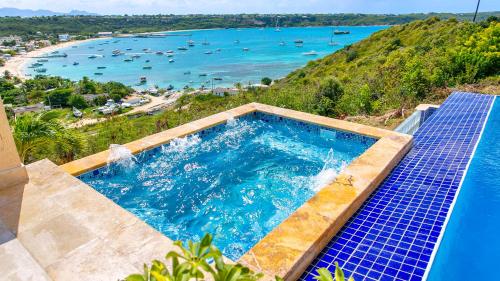 a swimming pool with a view of the ocean at Villa Nirvana in North Hill Village