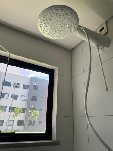 a shower head in a room with a window at Apartamento confortável, calmo e bem localizado in Lucas do Rio Verde