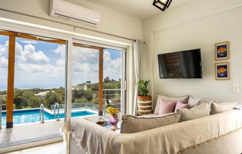 a living room with a white couch and a large window at Thyme 1 in Agia Galini