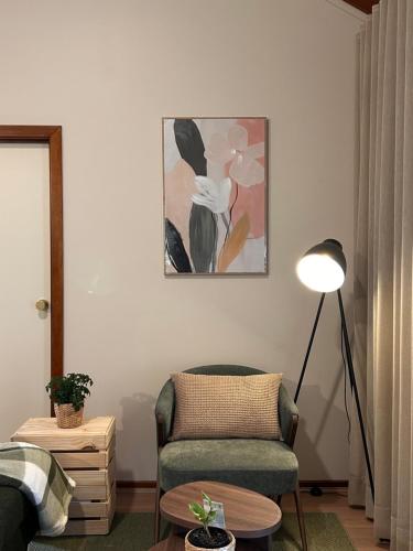 a living room with a chair and a lamp at 12 apostles cottages in Princetown