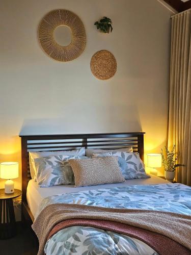 a bedroom with a bed with pillows and two lamps at 12 apostles cottages in Princetown