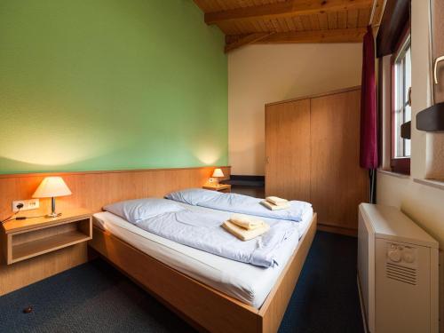 a bedroom with a bed with a green wall at Ferienhaus im Trixi Ferienpark in Großschönau