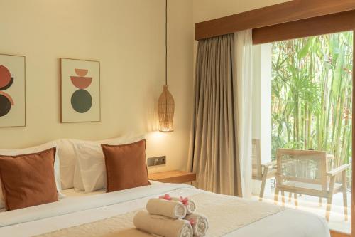 ein Hotelzimmer mit einem Bett und einem großen Fenster in der Unterkunft Reset Lombok Hotel in Kuta Lombok