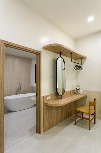 a bathroom with a tub and a sink with a mirror at Siwara poolvilla in Jomtien Beach