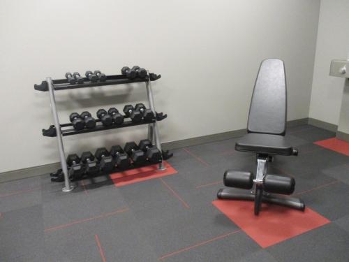 a gym with a rack of dumbbells and a chair at Days Inn & Suites by Wyndham Warman in Warman
