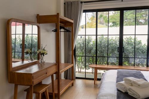 a bedroom with a desk and a bed and a window at Siwara poolvilla in Jomtien Beach