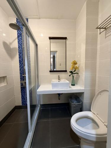 a bathroom with a sink and a toilet at Hotel Tiffany - Laoag in Laoag