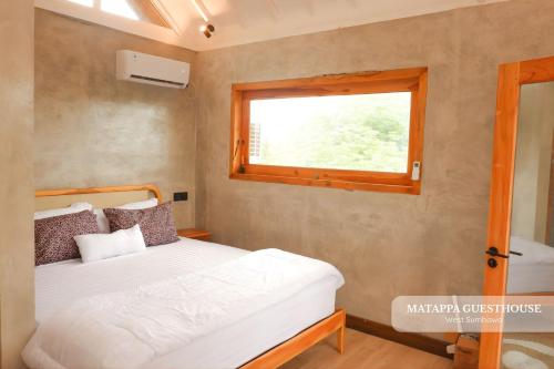 a small bedroom with a bed and a window at Matappa Guest House in Pulau Sarang