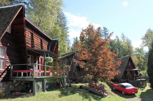 a house with a red car parked in front of it at Sunny Bluffs Chalets in Kaslo