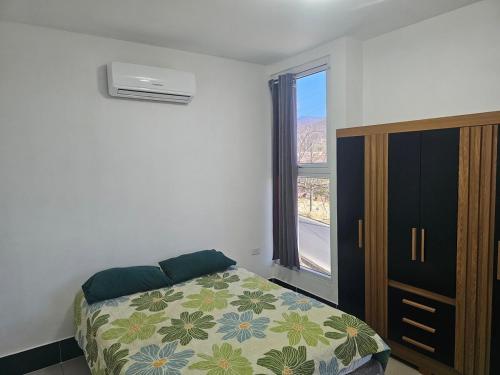 a bedroom with a bed and a dresser and a window at Modern AC Excellent location in Los Jocotes
