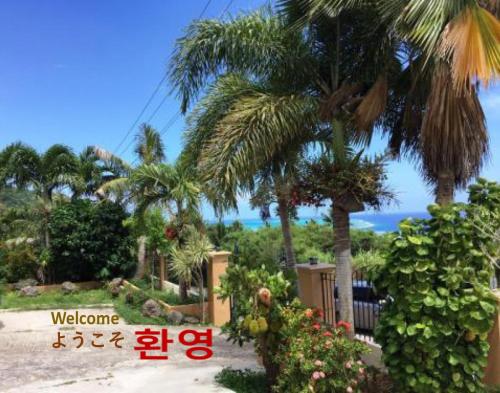 a view of a resort with palm trees and the ocean at Saipan Emerald Villa in Saipan