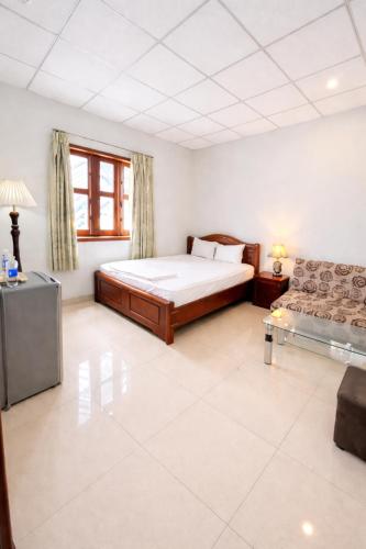 a large bedroom with a bed and a couch at Lina Hotel Hồ Chí Minh in Dĩ An