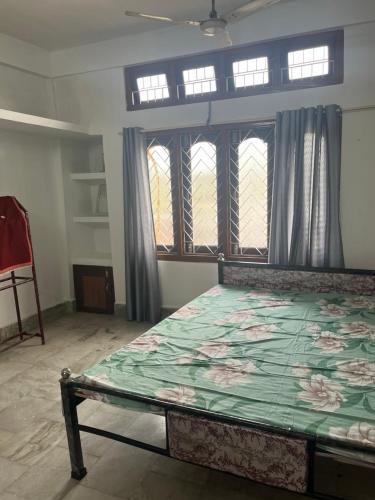 a bedroom with a large bed with a flower pattern on it at Aura house in Jorhat