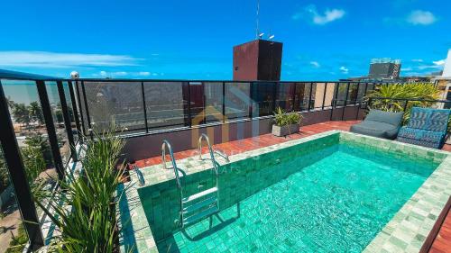 a swimming pool on the roof of a building at Áurea Bauten Cabo Branco Genius Flats in João Pessoa