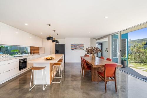 an open kitchen with a wooden table and chairs at Beachside Banksia in East Ballina
