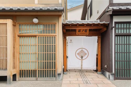 a gate with a door with a tree on it at 谷町君 星屋 樨ノ宿 清水寺 in Kyoto