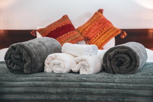 a pile of towels and towels on a bed at Hakuba Slopeside Chalet in Otari