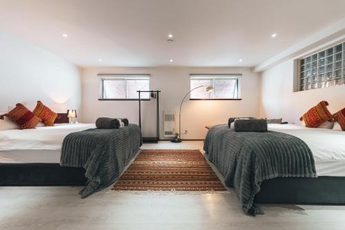 a bedroom with two beds and a rug at Hakuba Slopeside Chalet in Otari