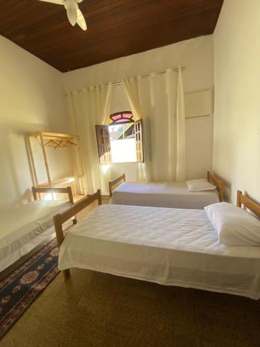 a bedroom with two beds and a ceiling at Casa para a temporada com 3 quartos a caminho do centro in Porto Seguro