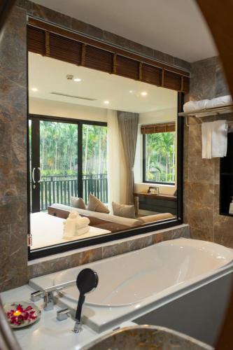 a bathroom with a large mirror over a tub at Thung Nham Resort in Ninh Binh