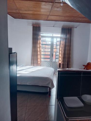 a bedroom with a bed and a window with curtains at Apartaestudio Central in Chiquinquirá