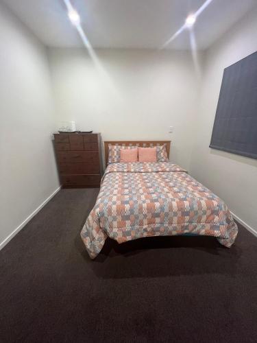 a bedroom with a bed and a dresser in it at Rana Niwas in Rolleston