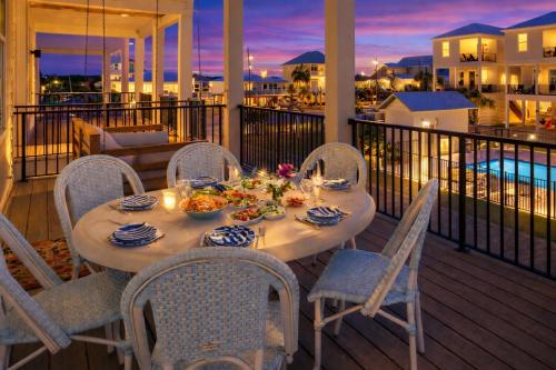 a table on a balcony with a meal on it at The Hangout House by The Madison Liv Collection in Gulf Shores