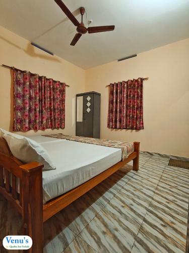 a bedroom with a bed and a ceiling fan at Venu's Homestay in Varkala