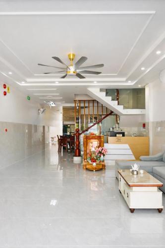 a living room with a ceiling fan and a couch at Anh Duy Hotel in Nhơn Trạch