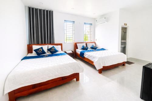 a bedroom with two beds and a television at Anh Duy Hotel in Nhơn Trạch