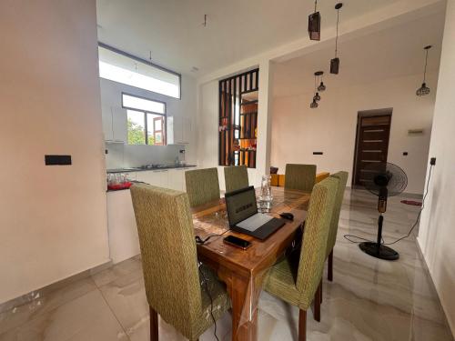 a dining room with a table with a laptop on it at Colombo - Kelaniya House in Kelaniya
