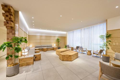 a lobby with a couch and tables and chairs at WAYPOINT TSUKIJI Tokyo in Tokyo