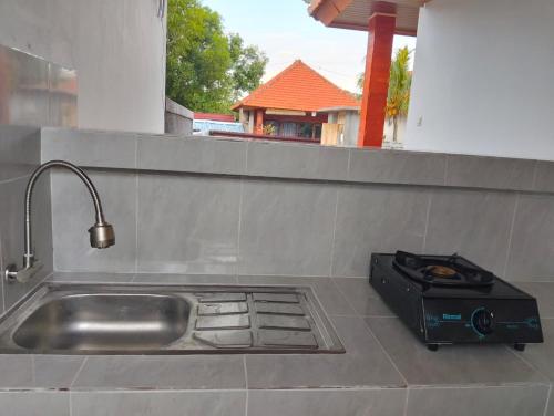 a kitchen counter with a stove and a sink at Japa Amerta Villa in Amed