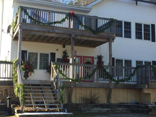 a porch with a deck with christmas wreaths on it at Little Hawk Resort & Marina in Algonquin Highlands