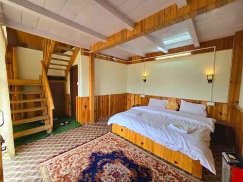 a bedroom with a large bed in a room with wooden walls at The Ridge Cottages - Sainj Valley in Sainj