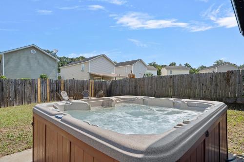 a hot tub in a backyard with a fence at Cozy 2 Bedroom Duplex In Charlotte, Jacuzzi, Sleeps 6 plus 2 in Charlotte